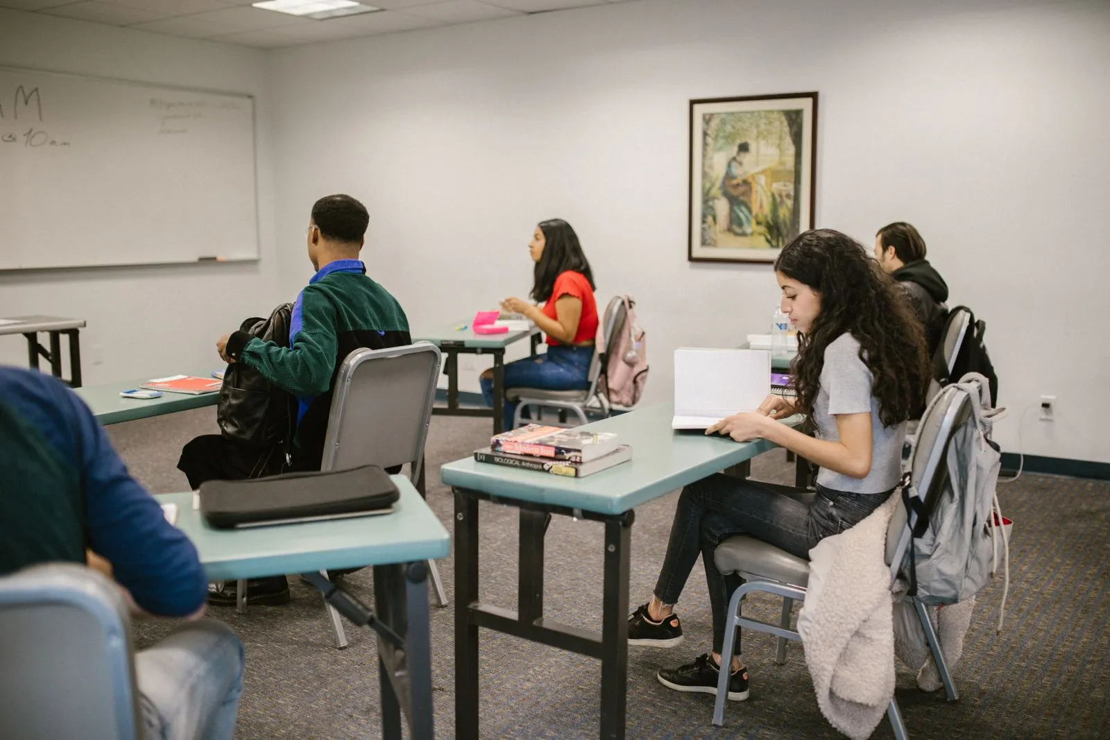 Un'aula con alcune persone sedute ai banchi durante un corso